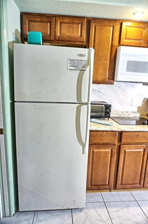 20921 Haulover Cove Road, Unit F5 Lutz, FL 33558 - Photo 11 of 34 a white refrigerator freezer sitting in a kitchen