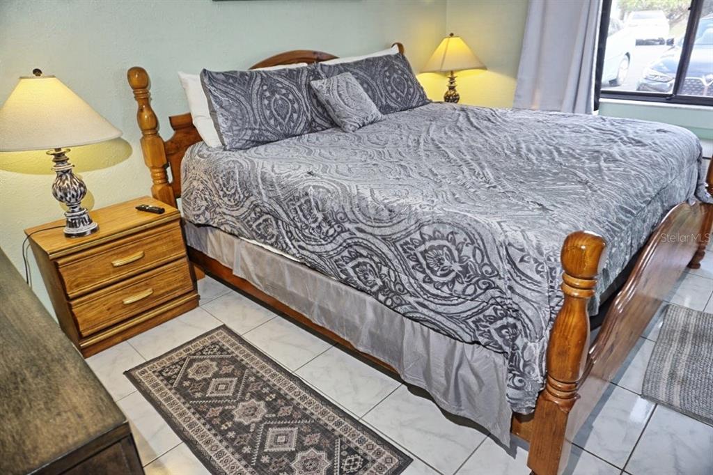 20921 Haulover Cove Road, Unit F5 Lutz, FL 33558 - Photo 14 of 34 a bedroom with a bed and lamp with the dresser