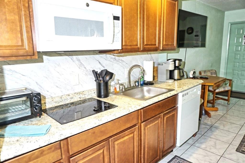 20921 Haulover Cove Road, Unit F5 Lutz, FL 33558 - Photo 8 of 34 a kitchen with stainless steel appliances granite countertop a sink and a microwave
