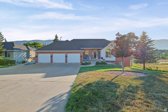 4117 North Wolf Ridge Circle Eden, UT 84310 - Photo 57 of 63 Brick and siding exterior featuring a three-car garage and a paved driveway