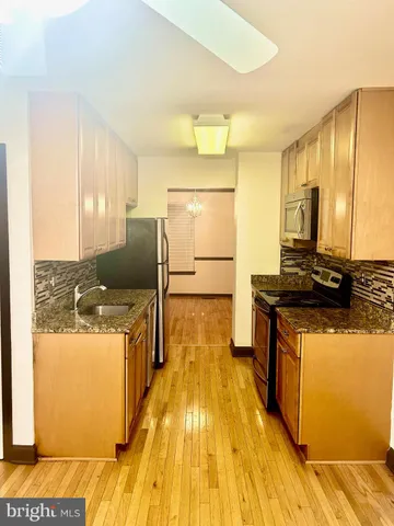 a kitchen with stainless steel appliances granite countertop a stove and a refrigerator