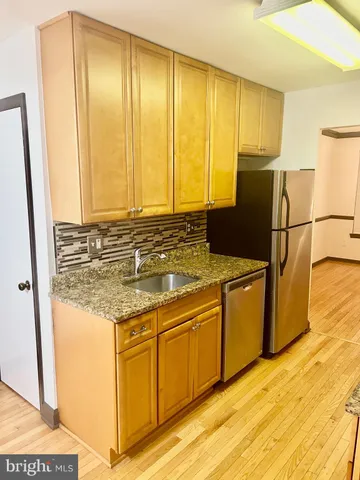 a bathroom with a granite countertop sink and a large mirror