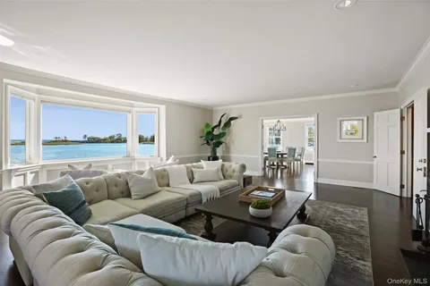 a bedroom with a bed a table and large windows