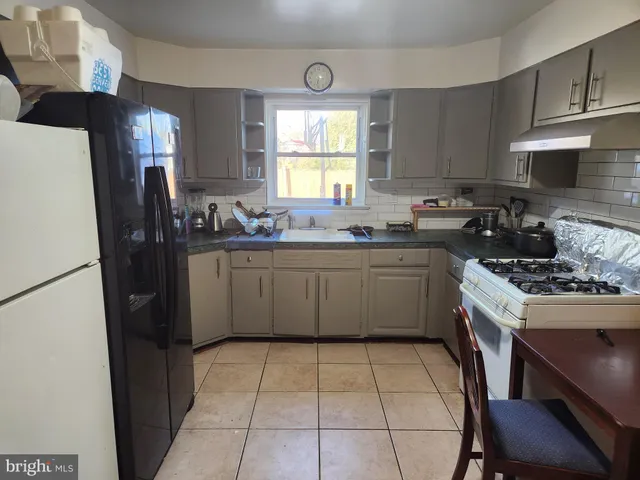 a kitchen with a stove a sink a refrigerator and cabinets