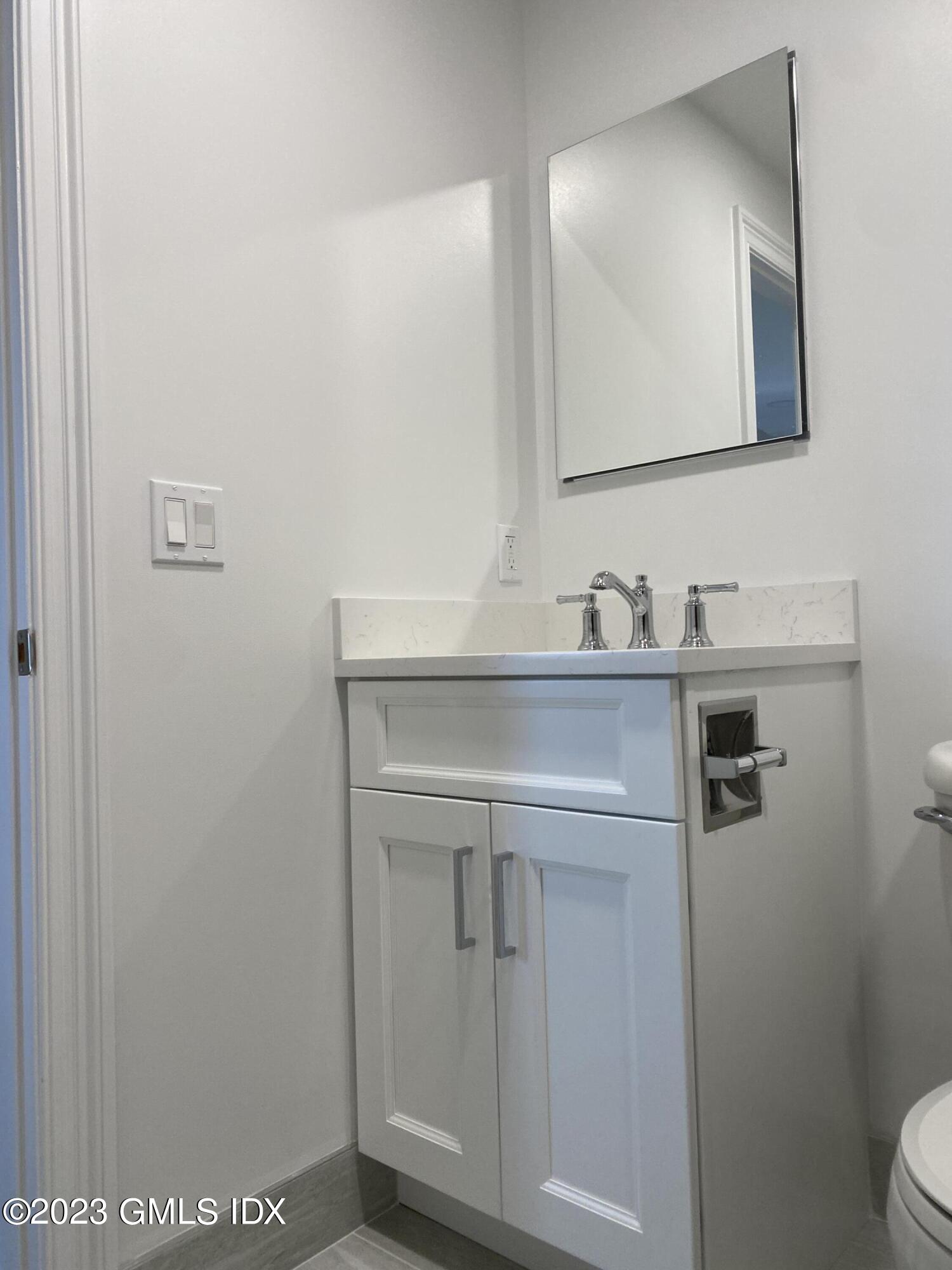 11 Old Field Point Road, Unit 2A Greenwich, CT 06830 - Photo 11 of 12 a bathroom with a sink a toilet and mirror