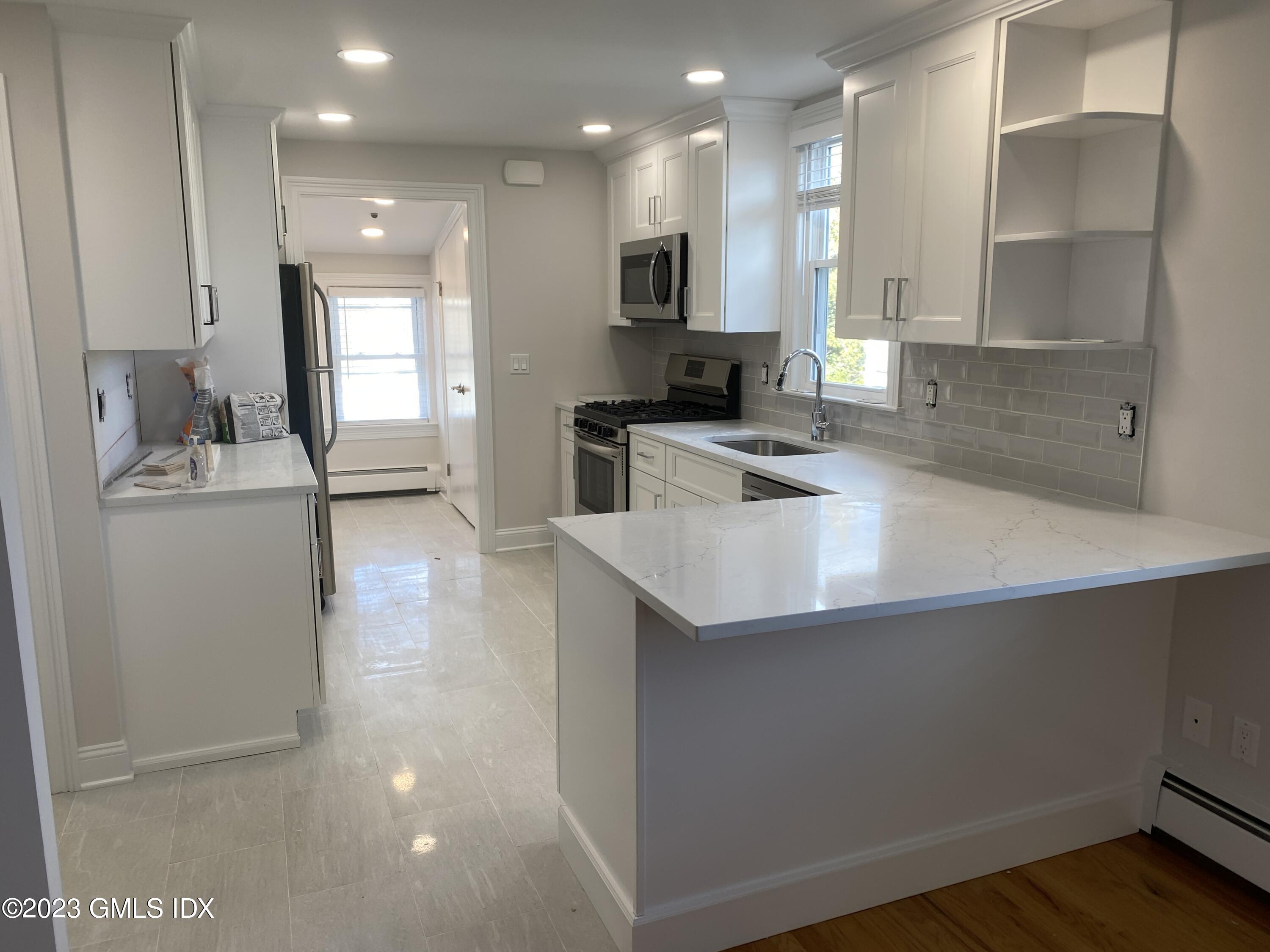 11 Old Field Point Road, Unit 2A Greenwich, CT 06830 - Photo 3 of 12 a kitchen with stainless steel appliances granite countertop a sink stove and refrigerator