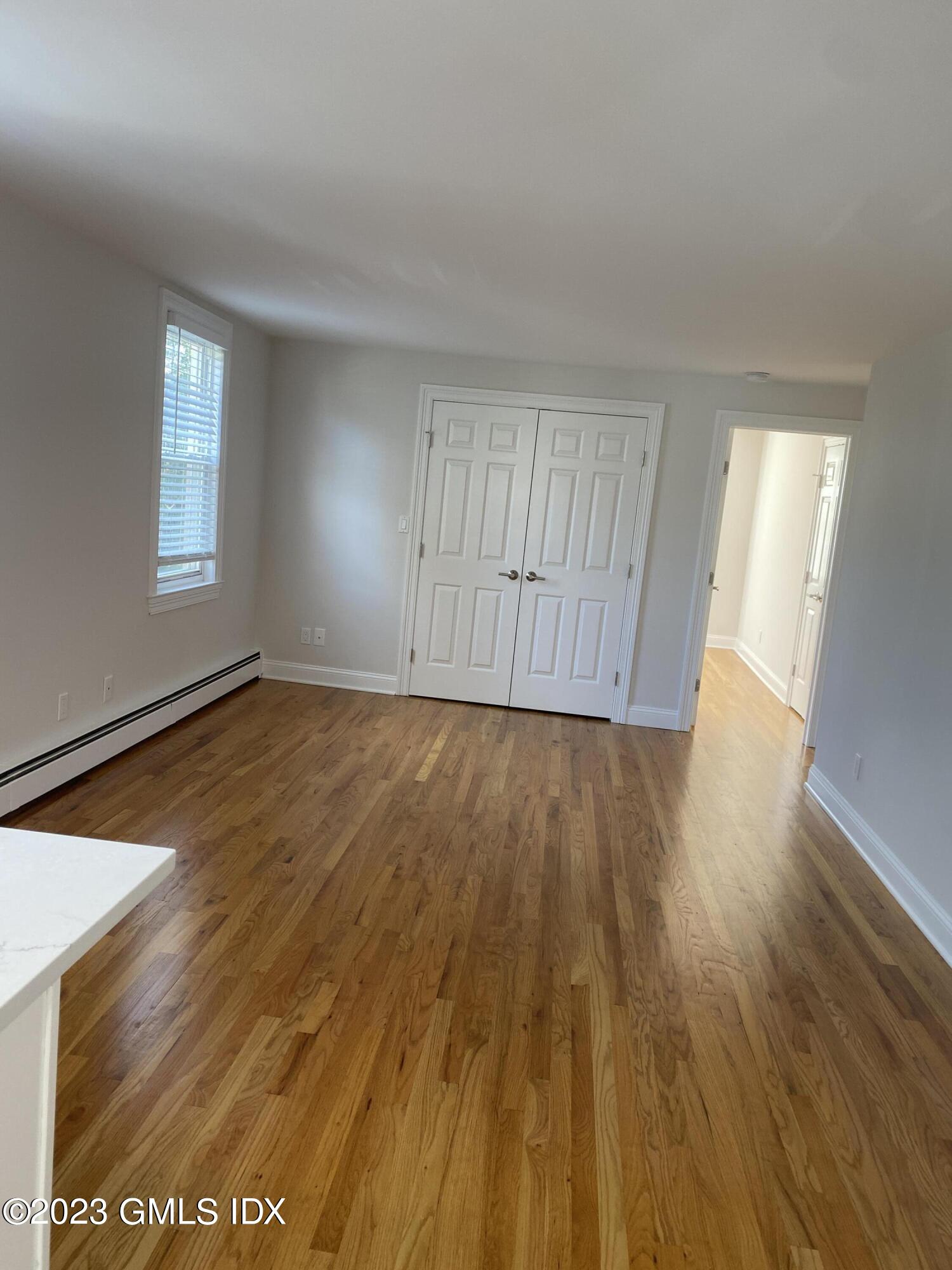 11 Old Field Point Road, Unit 2A Greenwich, CT 06830 - Photo 7 of 12 an empty room with wooden floor and windows