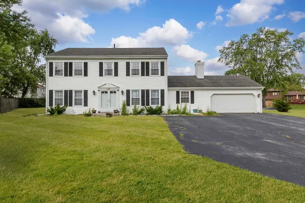 a front view of a house with a garden and yard