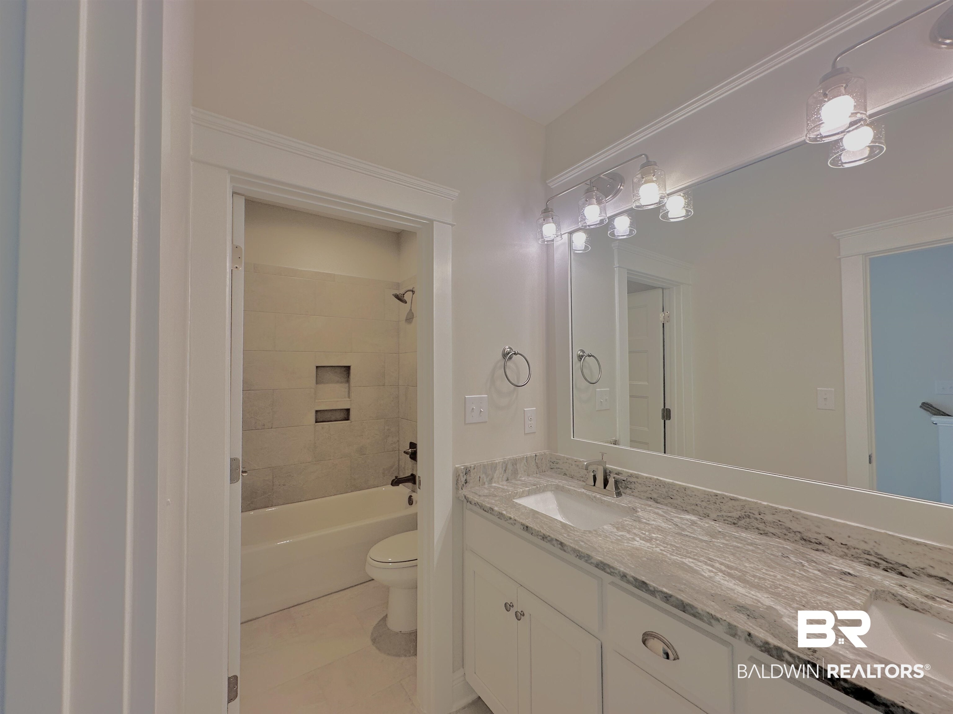 691 Kitfox Avenue Fairhope, AL 36532 - Photo 17 of 42 Full bathroom with tile patterned floors, vanity, toilet, and tiled shower / bath combo