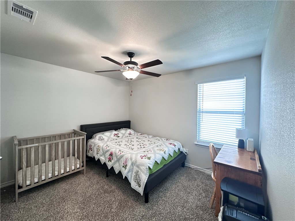 7649 Herd Rider Lane Corpus Christi, TX 78414 - Photo 16 of 18 a bedroom with a bed and a chandelier