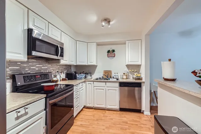 a kitchen with stainless steel appliances granite countertop a stove sink microwave and cabinets