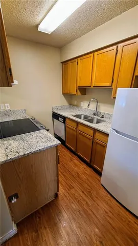 a kitchen with granite countertop wooden floors and wide window