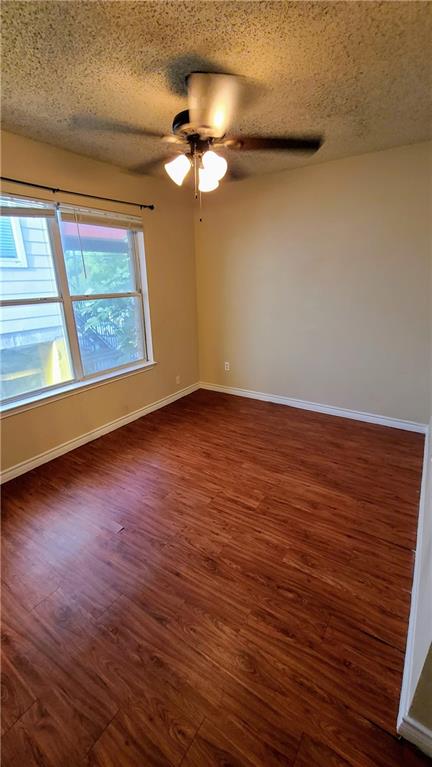 1907 Robbins Place, Unit 201 Austin, TX 78705 - Photo 3 of 5 Spare room featuring dark wood-style floors, a textured ceiling, and ceiling fan