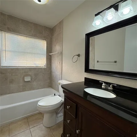 a bathroom with a shower sink and mirror