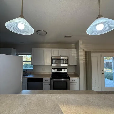 a kitchen with stainless steel appliances granite countertop a stove and cabinets