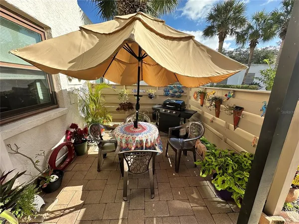 a view of a patio with table and chairs and potted plants
