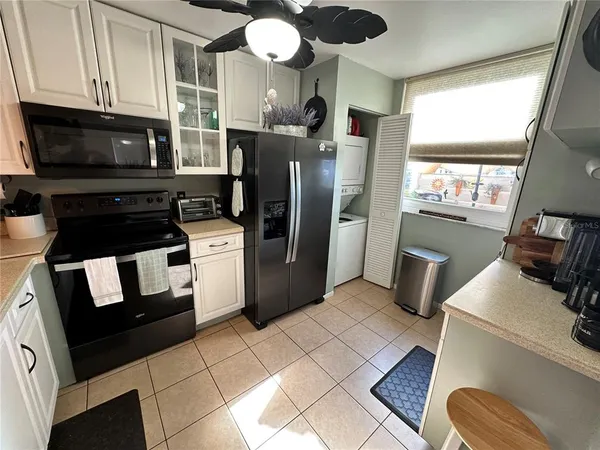 a kitchen with granite countertop a refrigerator stove and microwave