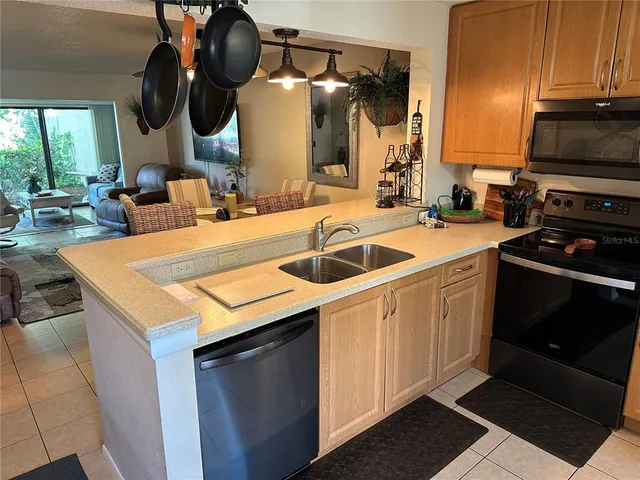 a kitchen with a sink dishwasher and a stove with wooden floor