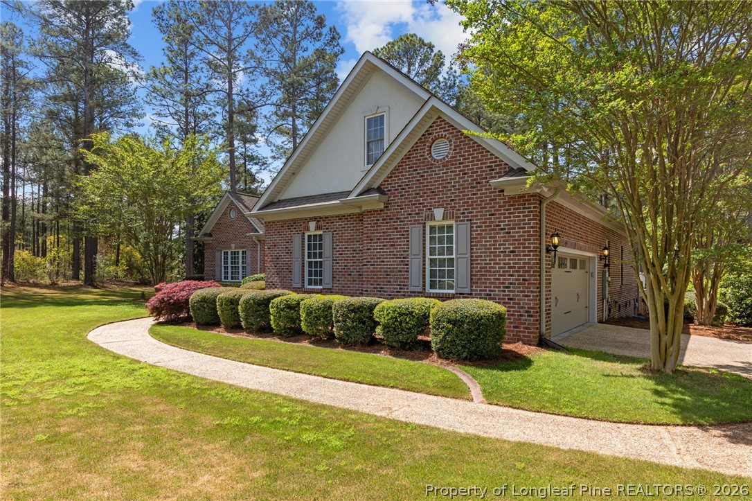 30180 East Lake Road Wagram, NC 28396 - Photo 2 of 42 a front view of a house with a yard and garage