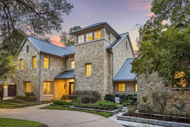 a large kitchen with stainless steel appliances a stove a sink dishwasher and a dining table with white cabinets