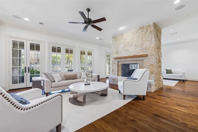 a dining room with wooden floor a chandelier a wooden table and chairs