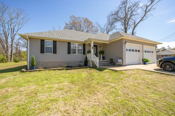 a front view of a house with cars parked