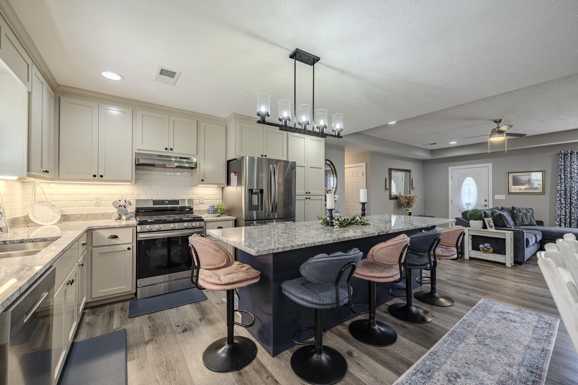 50 Perry Place Savannah, TN 38372 - Photo 3 of 38 a kitchen with stainless steel appliances granite countertop a sink a stove a dining table and chairs with wooden floor