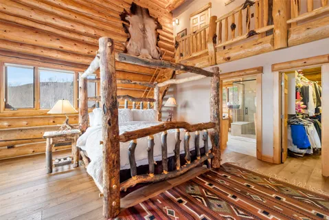 a bedroom with a bed couch and a large window