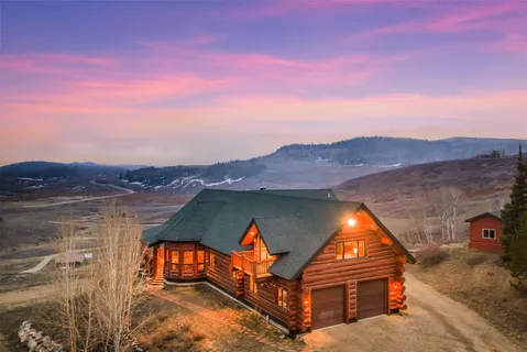 an aerial view of a house with swimming pool and mountains