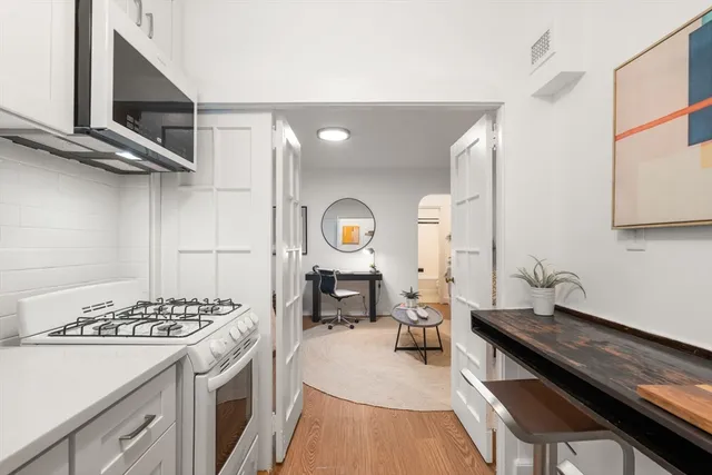 a kitchen with a stove and a wooden floor