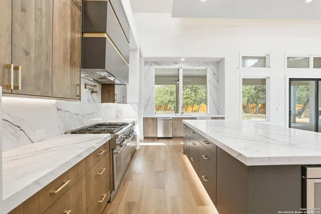 a kitchen with stainless steel appliances granite countertop a sink and a stove