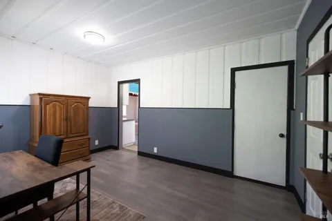 a view of an empty room with wooden floor