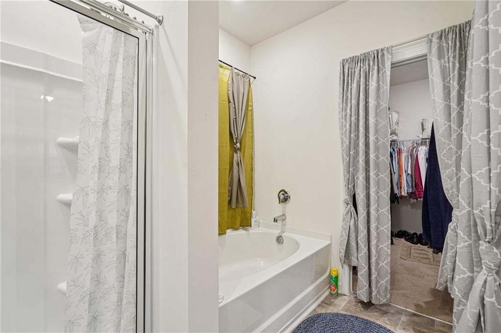 1729 Limousin Way Stockbridge, GA 30281 - Photo 13 of 18 a bathroom with a tub a sink and a large mirror