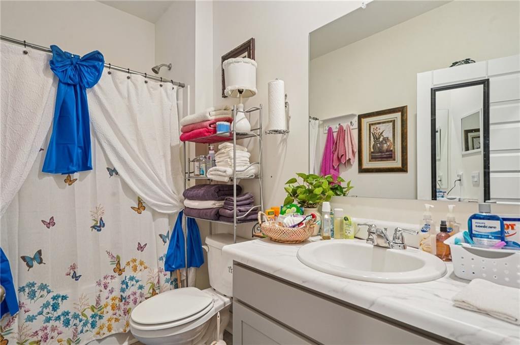 1729 Limousin Way Stockbridge, GA 30281 - Photo 9 of 18 a bathroom with a sink a toilet and shower curtain