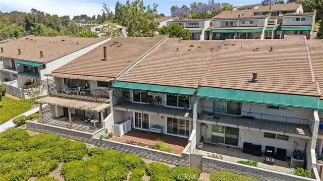 a view of a patio with couches table and chairs with wooden floor and fence