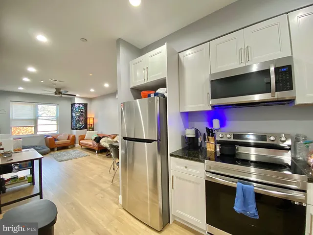 a kitchen with stainless steel appliances granite countertop a refrigerator sink and microwave