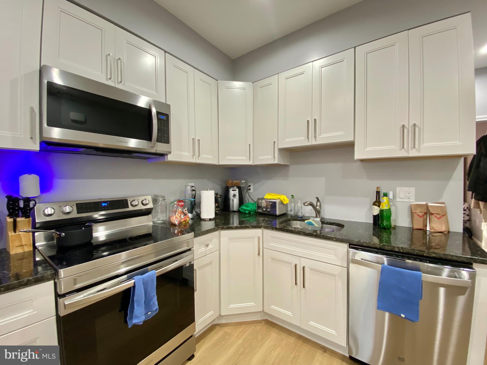 1932 North 8th Street, Unit 2 Philadelphia, PA 19122 - Photo 11 of 34 a kitchen with stainless steel appliances granite countertop grey cabinets a stove a sink and dishwasher