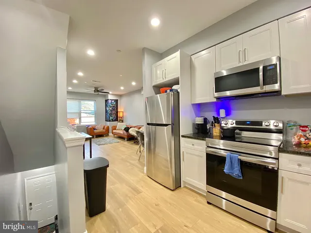 a kitchen with stainless steel appliances granite countertop a stove microwave and sink