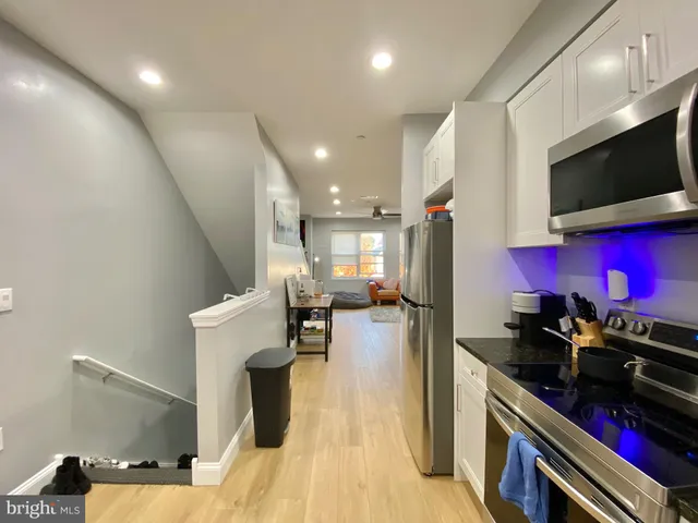 a kitchen with stainless steel appliances a refrigerator and a stove top oven