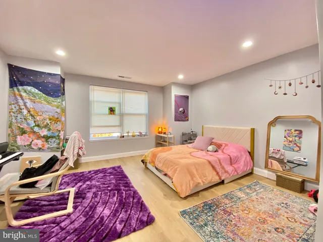 a spacious bedroom with a bed and a dresser