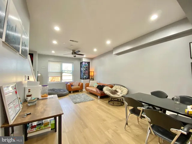 a living room with furniture a bed and a flat screen tv