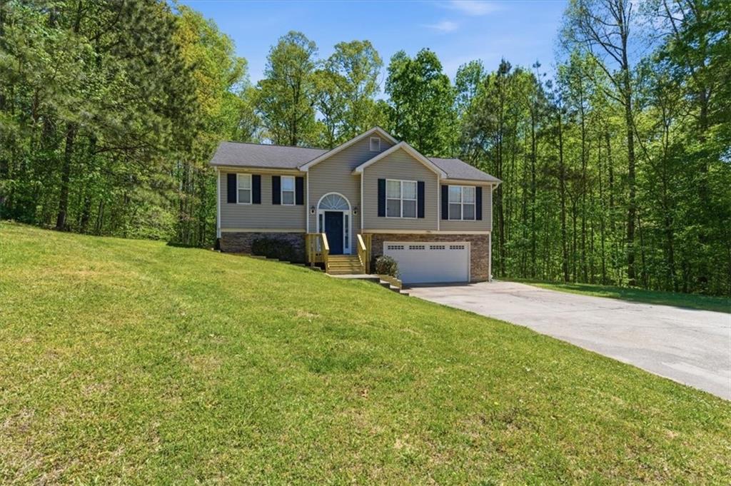 101 Brookcliff Court Temple, GA 30179 - Photo 1 of 1 a front view of a house with a garden and trees