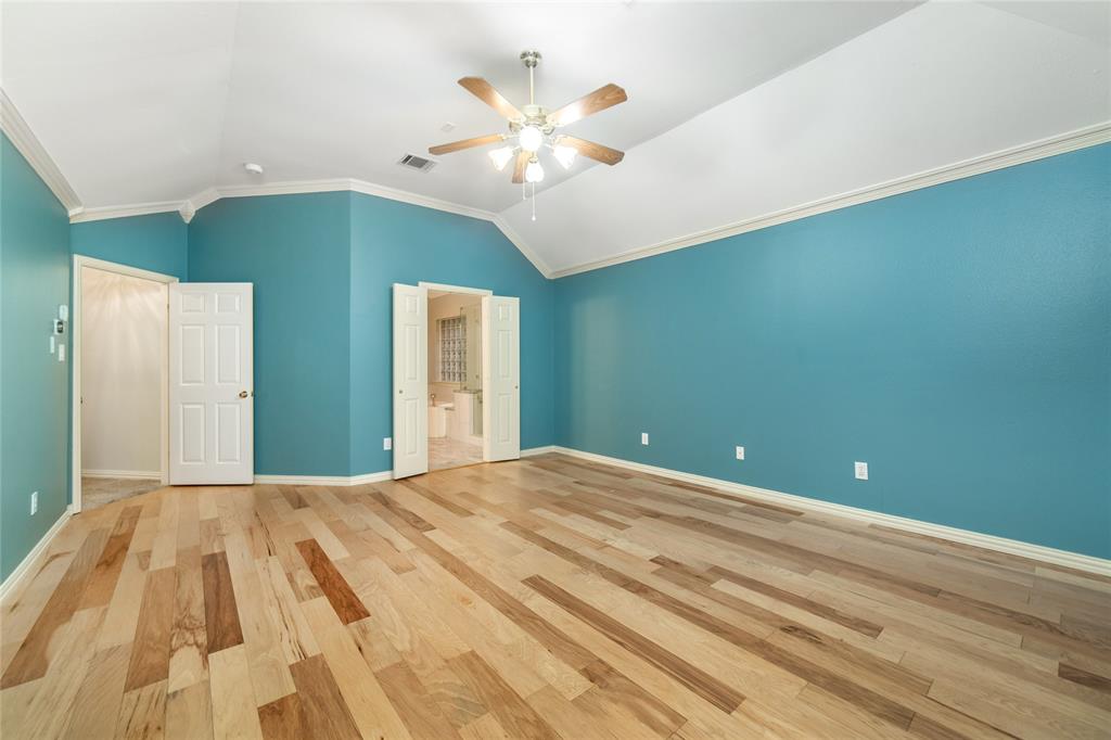 5801 Yeary Road Plano, TX 75093 - Photo 24 of 33 Spacious room featuring wood-finish flooring, vaulted ceilings, a ceiling fan with light fixture, and two sets of double doors