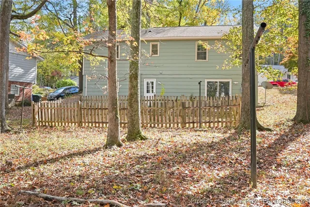 a front view of a house with a small yard and wooden fence