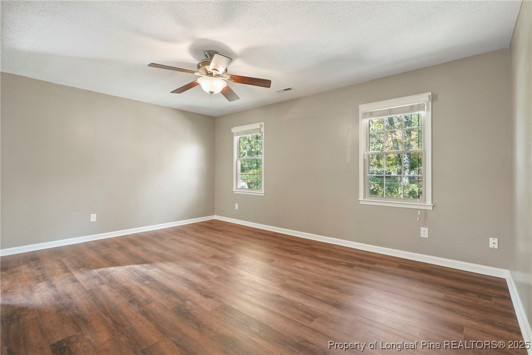 2308 Keith Drive Raleigh, NC 27610 - Photo 7 of 26 an empty room with wooden floor fan and windows