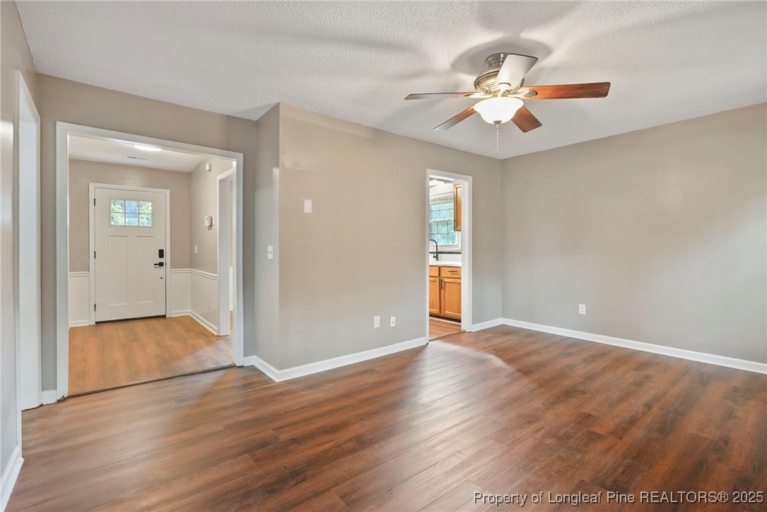 2308 Keith Drive Raleigh, NC 27610 - Photo 8 of 26 a view of an empty room with wooden floor and a ceiling fan