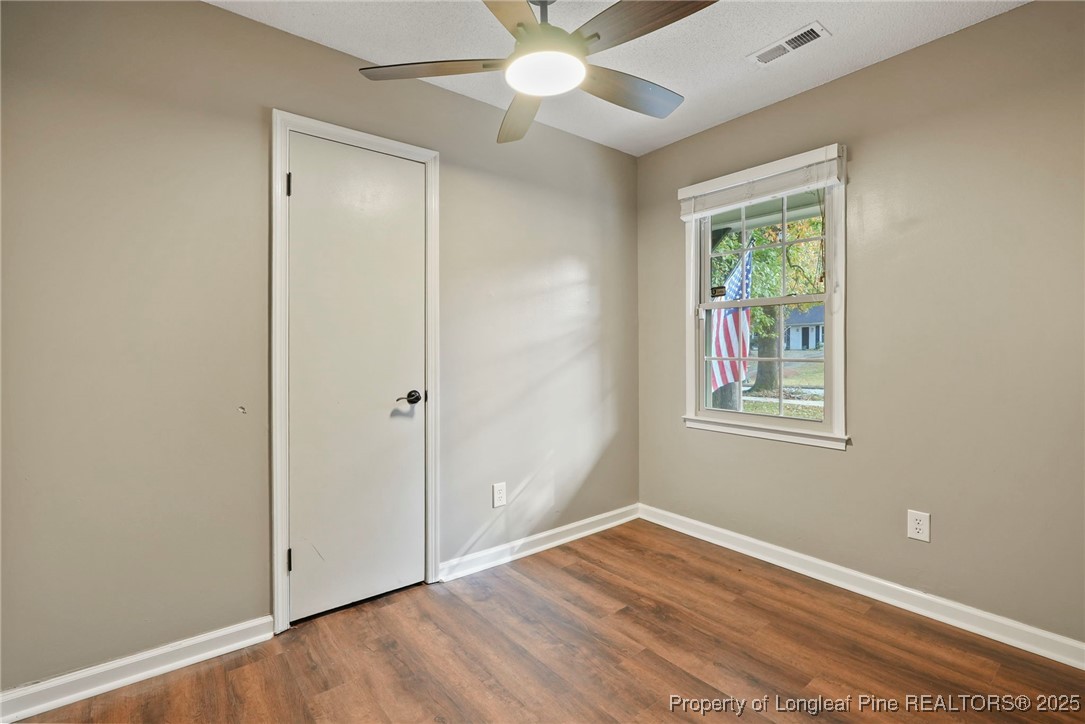 2308 Keith Drive Raleigh, NC 27610 - Photo 10 of 26 an empty room with wooden floor chandelier fan and windows