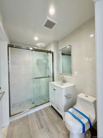 a spacious bathroom with a double vanity sink a mirror and a shower