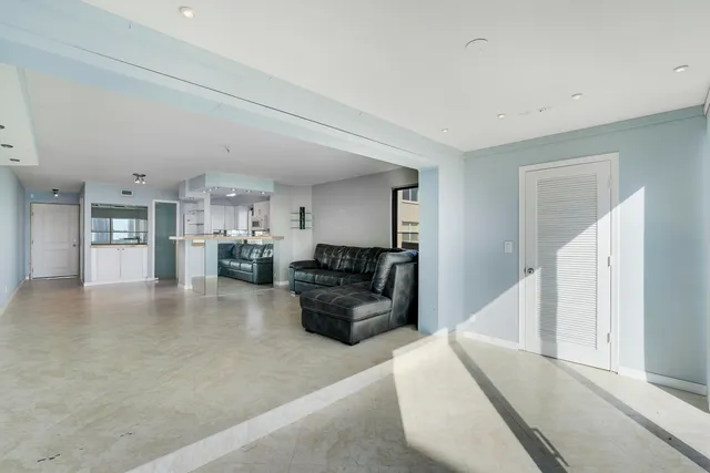 a living room with furniture and kitchen view