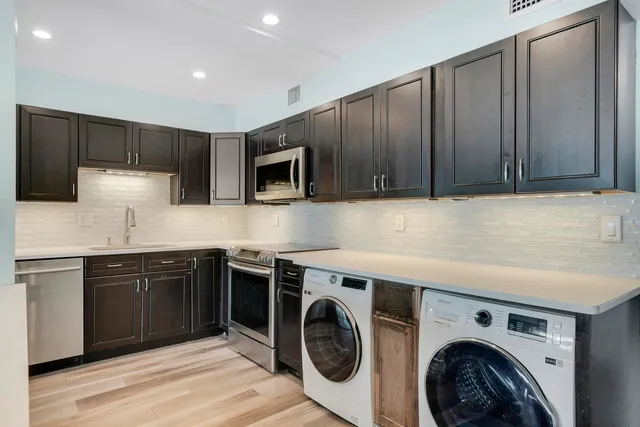 a kitchen with a sink a stove top oven and cabinets